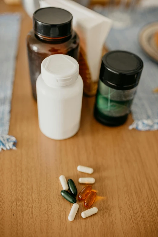 a variety of pills, tablets and medicine bottle sit on a table