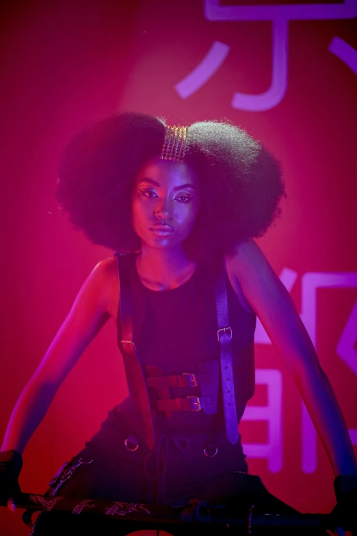 a woman with a large afro is standing behind some speakers