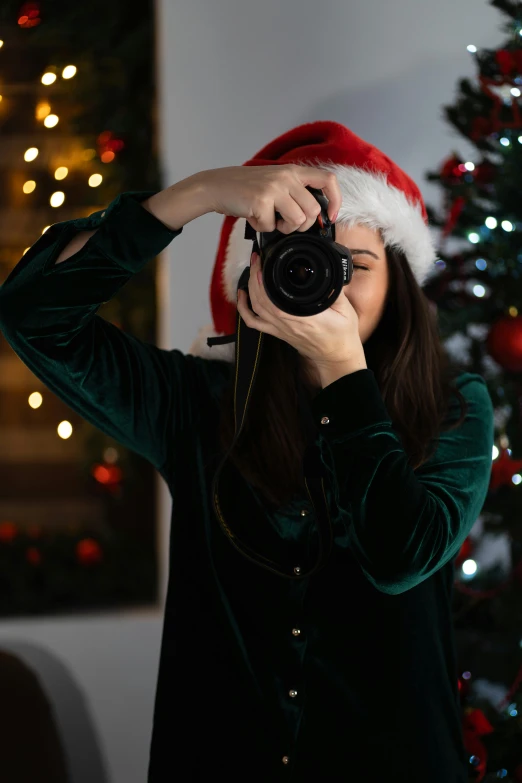 a girl with a camera taking pictures of christmas tree