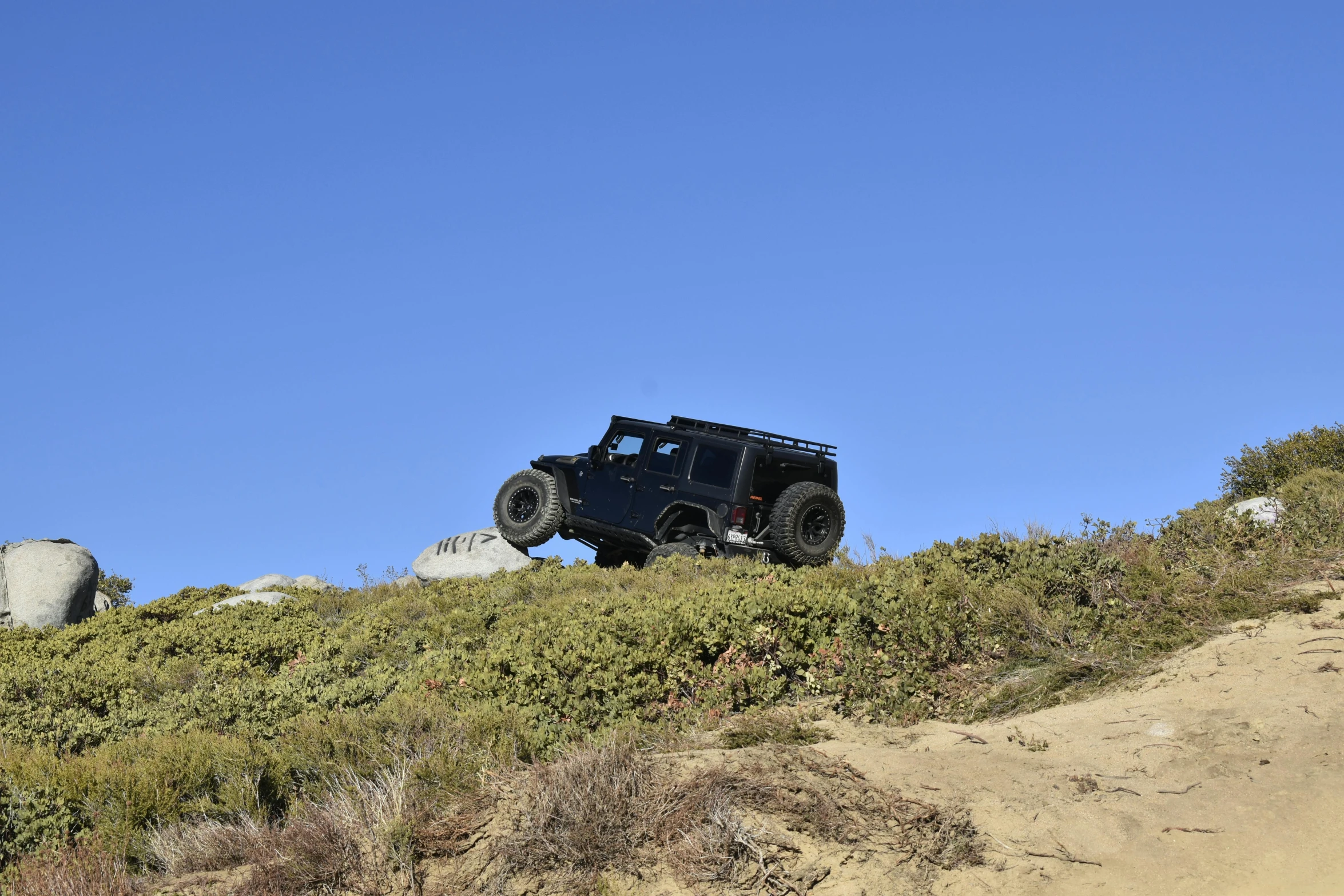 a 4x4 on top of a hill with large rocks