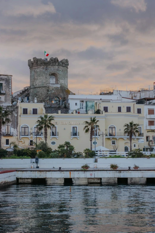 buildings on the coast next to the water with palm trees