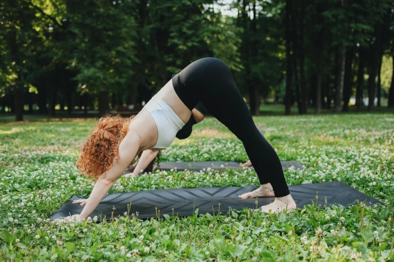 the woman is practicing her yoga outdoors