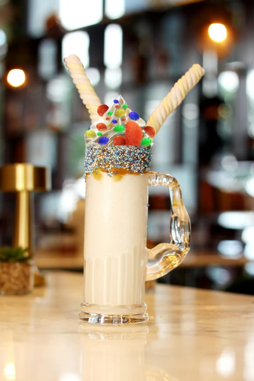 a glass mug with candy, candy and straw