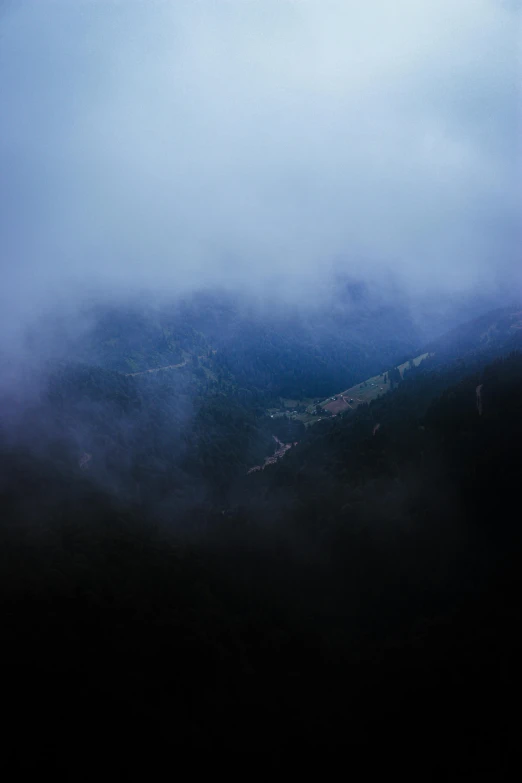 view of mountains with fog on top from a mountaintop