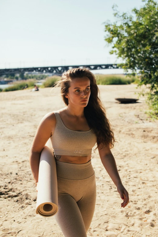 a woman is running on the beach holding a board