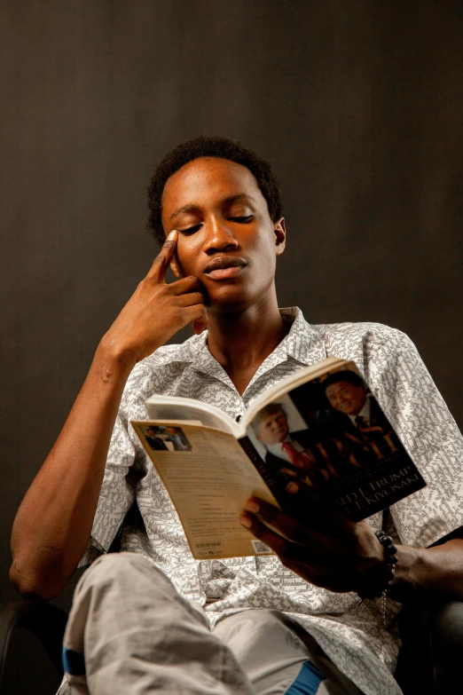 a young man sitting and reading a book