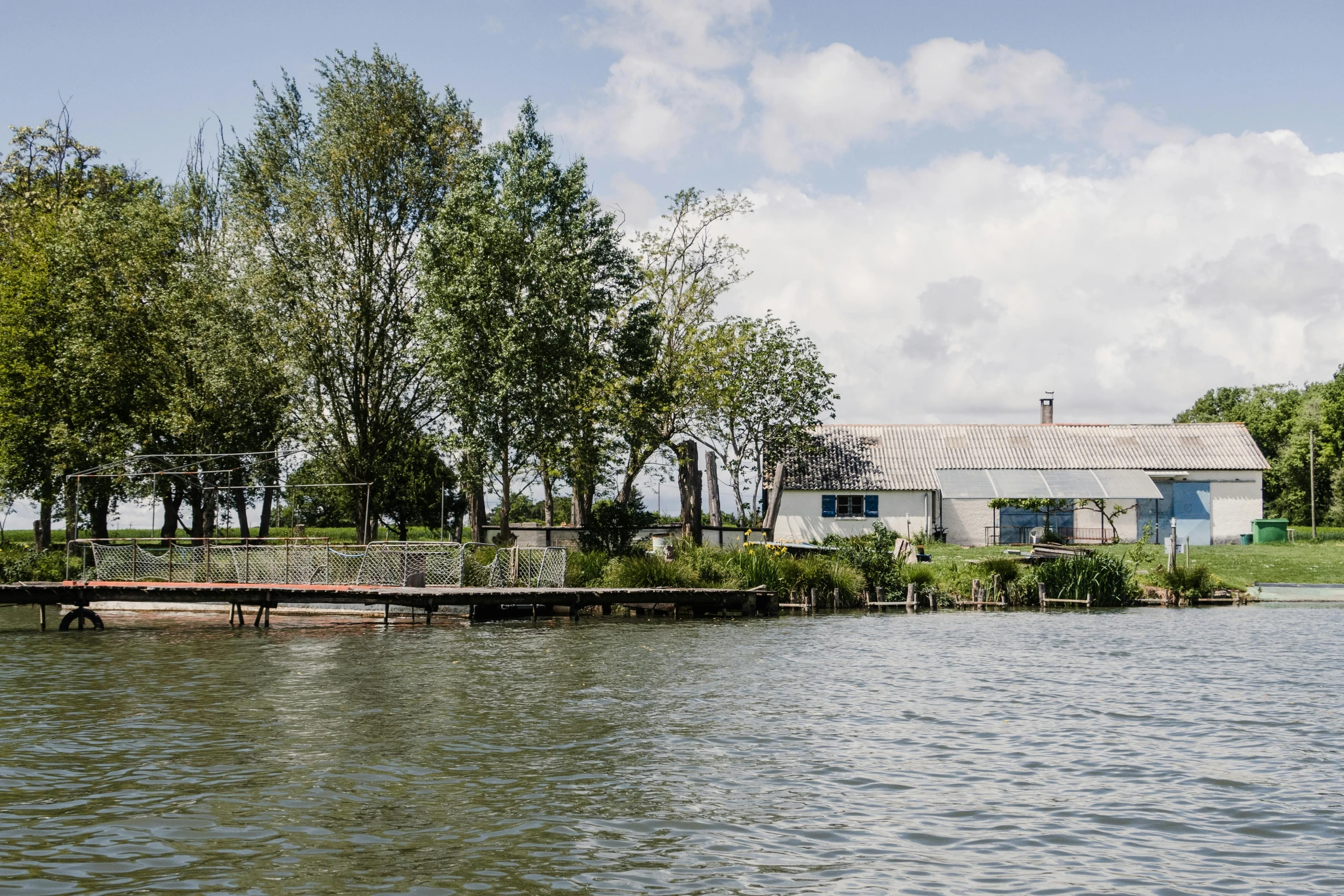 a large body of water next to trees and a house