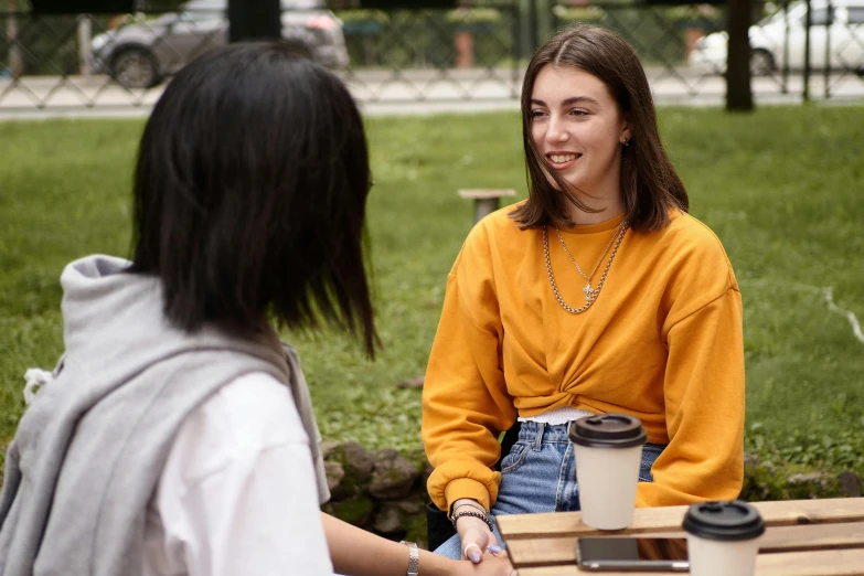 two girls smile at each other at a table