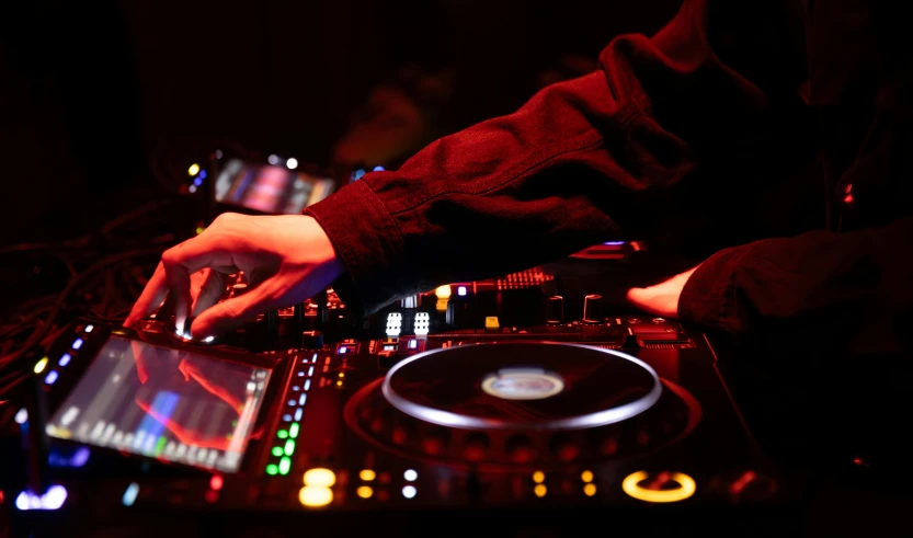 a dj is mixing some tracks in a club