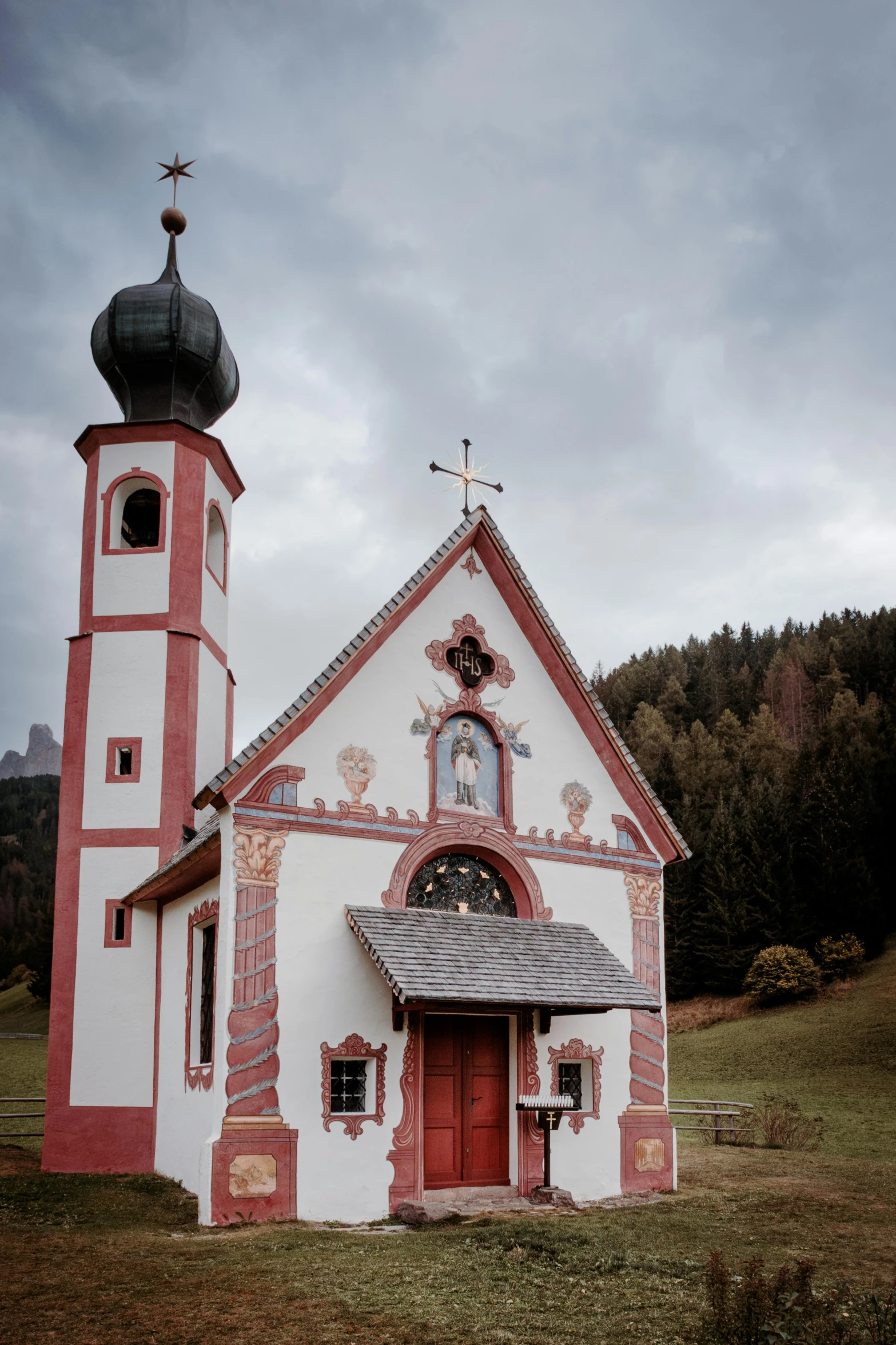 a white church in the countryside with a cross at its roof