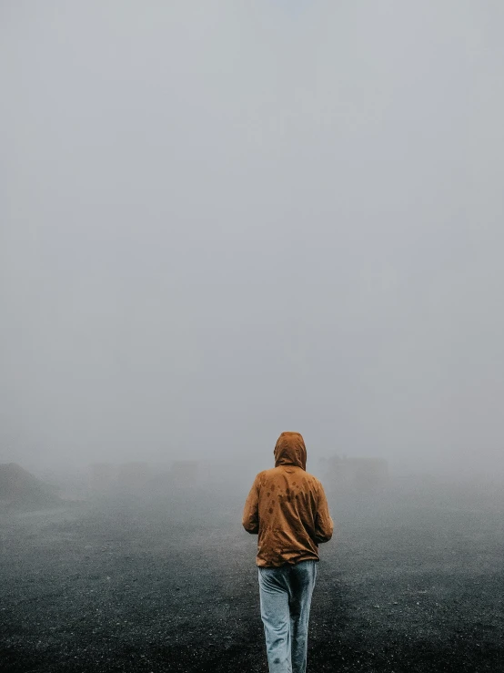 a person standing on the edge of a dark and gloomy field