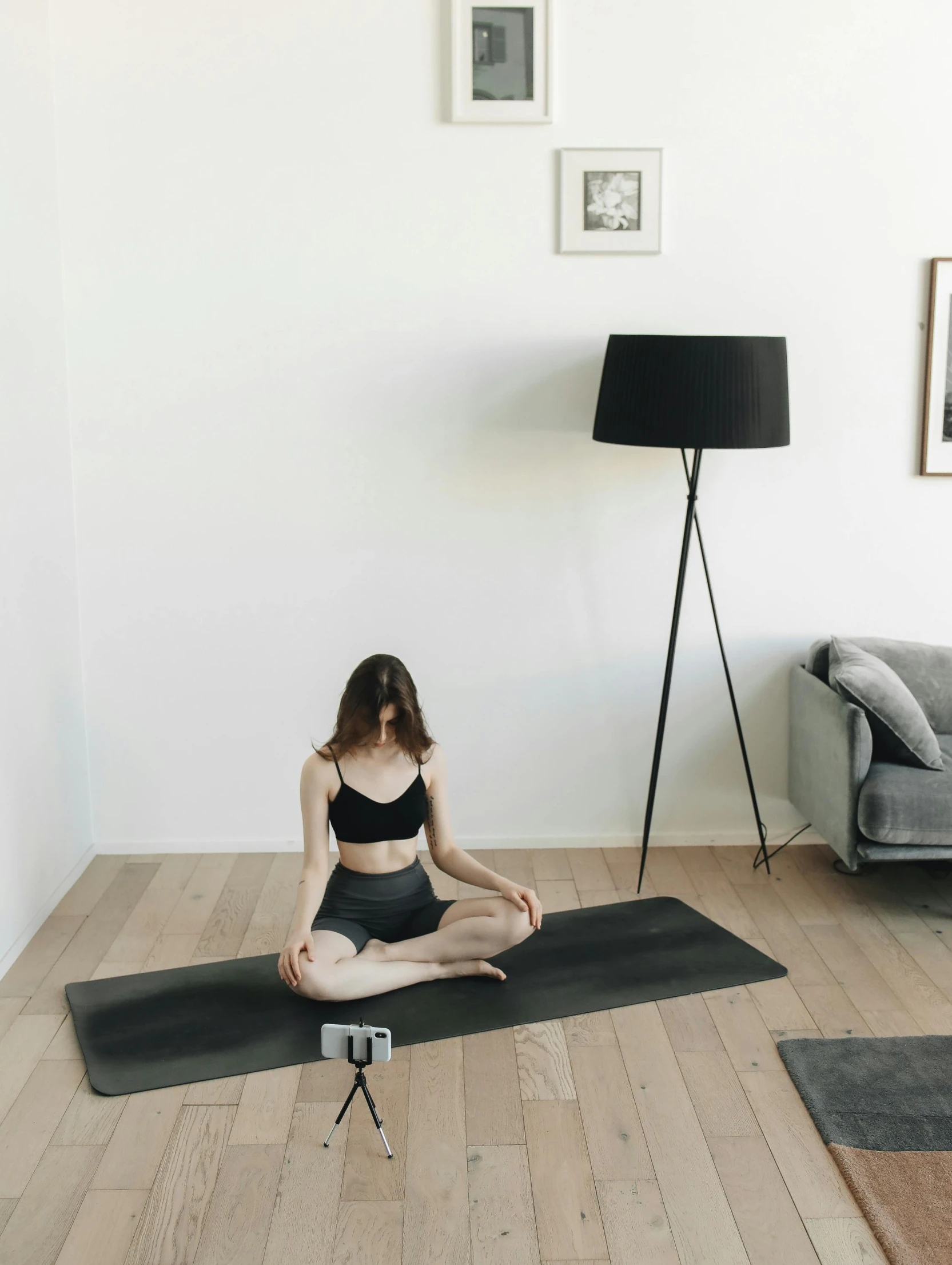 a woman sitting in yoga position on a mat