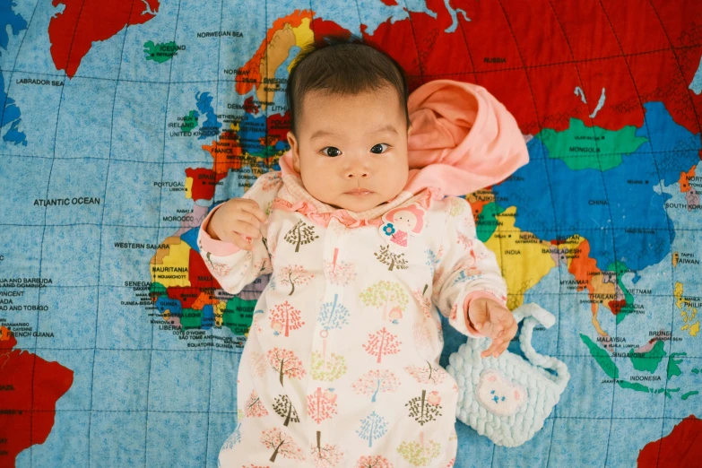 a baby laying on top of a world map