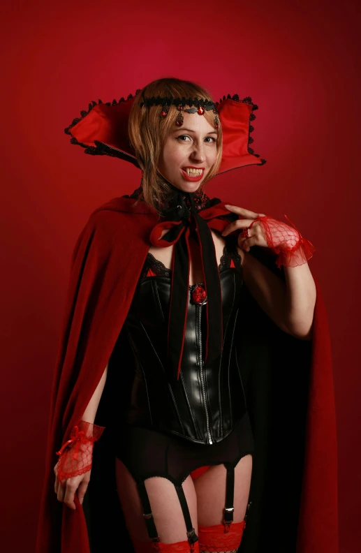 woman in costume with red cape on and eye makeup