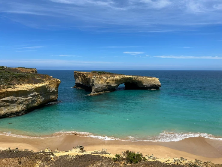 an ocean scene with a rock formation and two sea caves