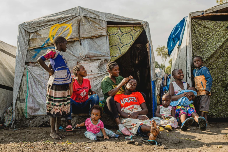 a group of people sitting in front of a tent