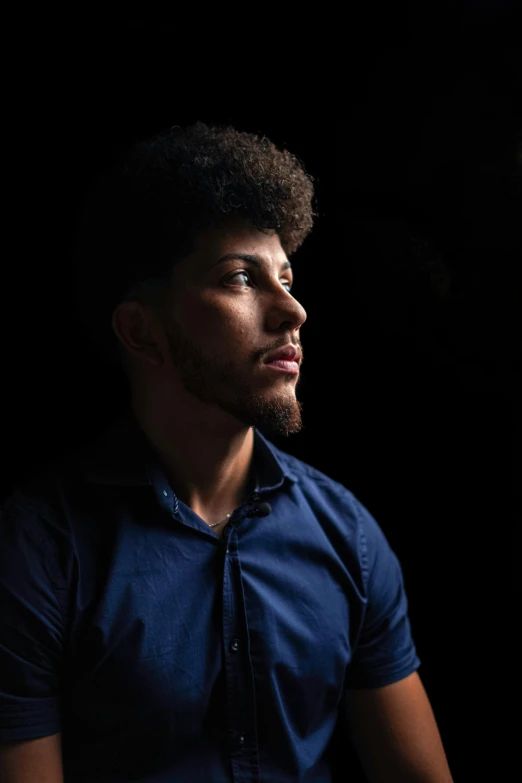 a black man in blue shirt posing for a picture