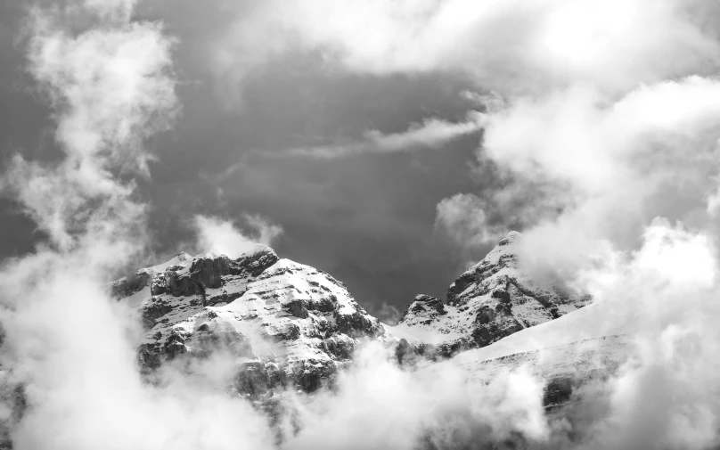 a mountain landscape with clouds moving in the wind