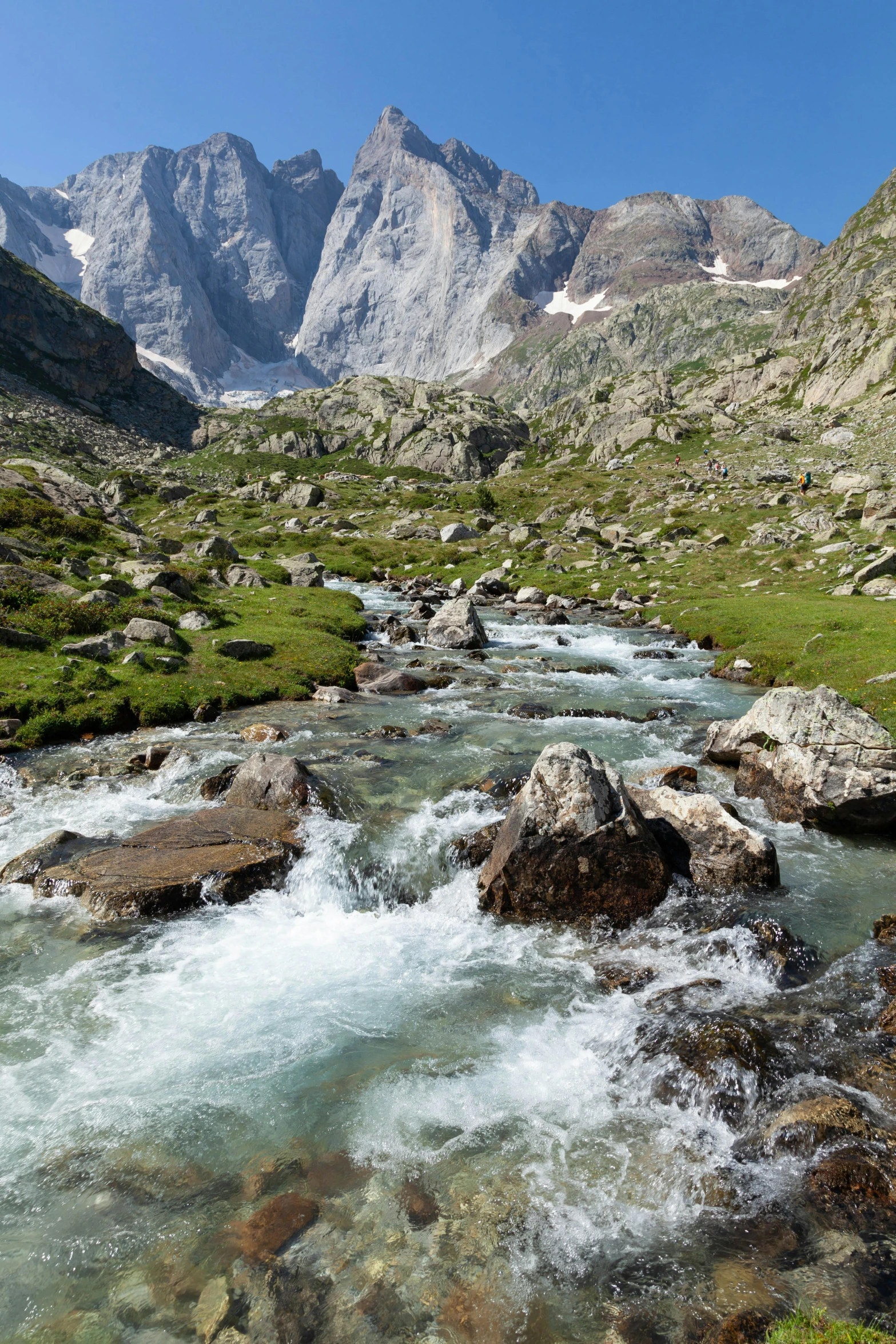 a view of some mountains with small creek in the foreground