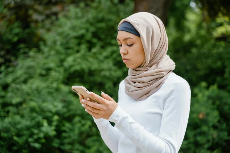 a beautiful woman standing holding a cell phone