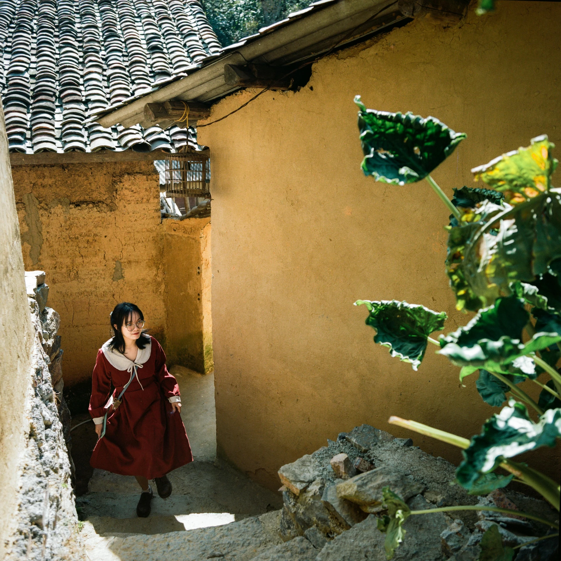 a woman in red clothes walking by a building