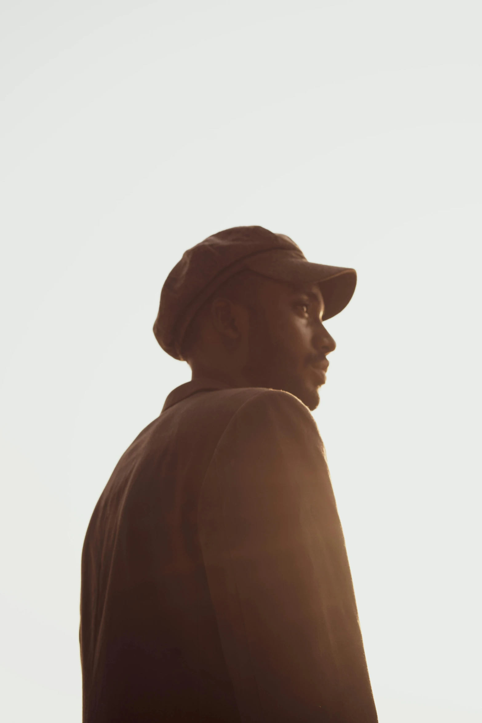 a man with a hat in front of a white sky