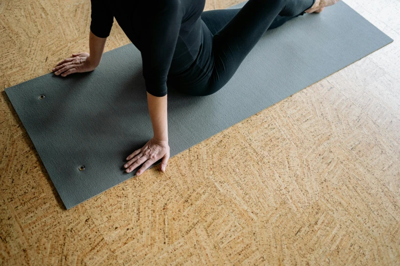 woman with hands on her hip on a yoga mat