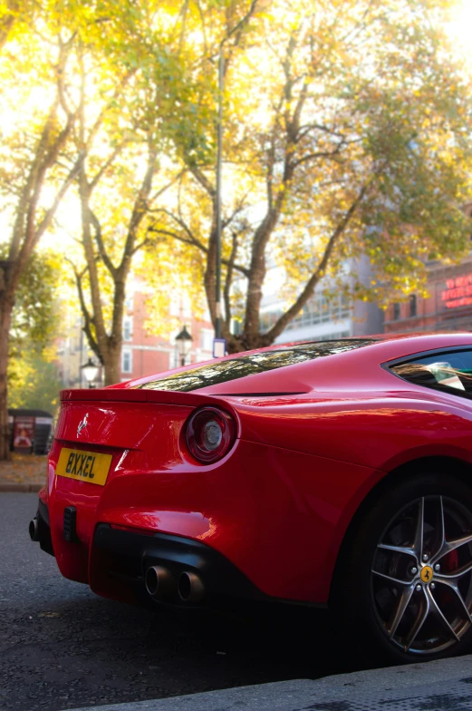 a red ferrari sports car parked in front of trees