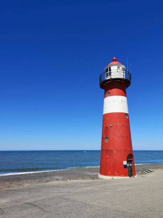 a light house sits on a sandy beach near the ocean