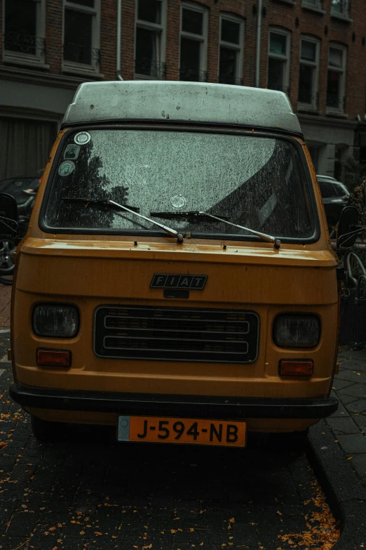 a small yellow van is parked on the street