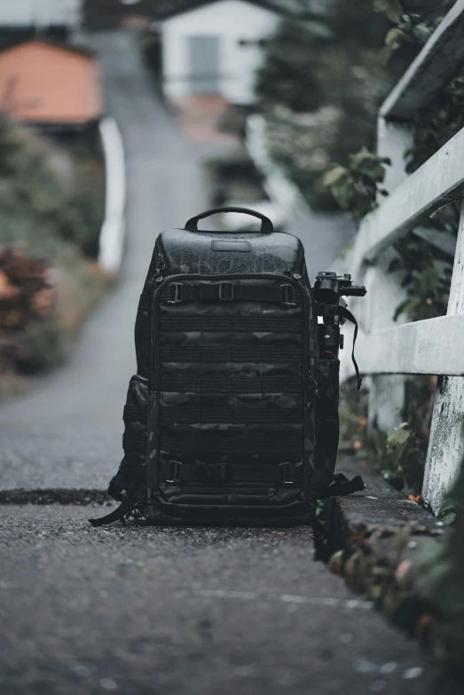 a backpack sitting on the ground by the fence