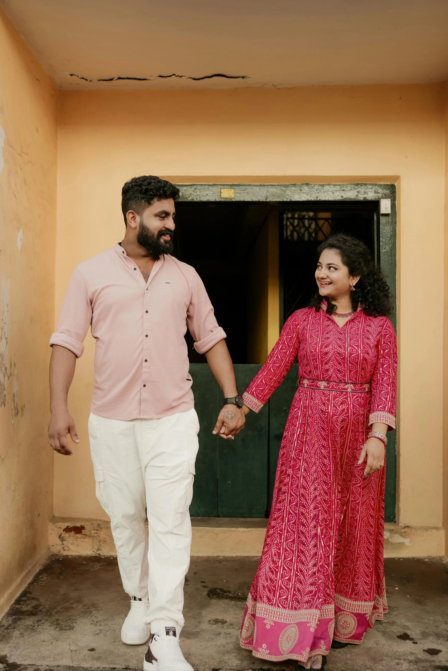 a man and a woman holding hands walk past a doorway