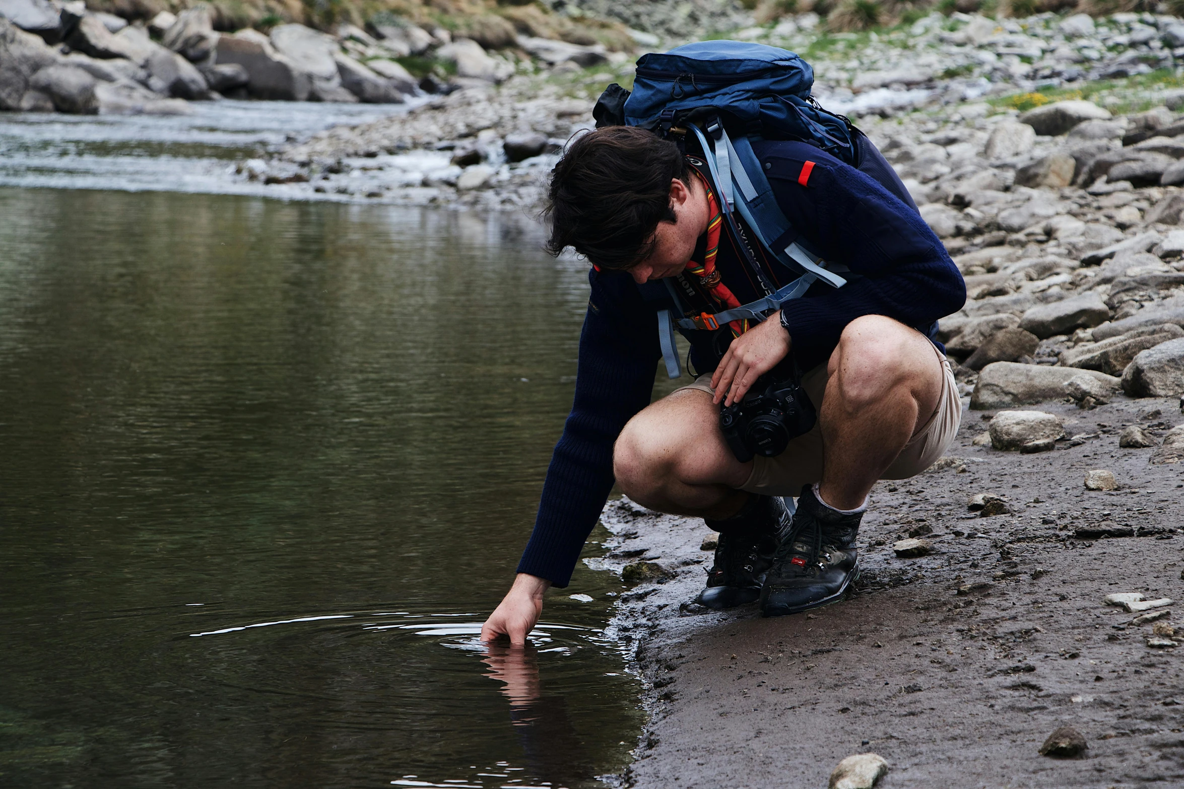 a man squatting and looking at a small fish