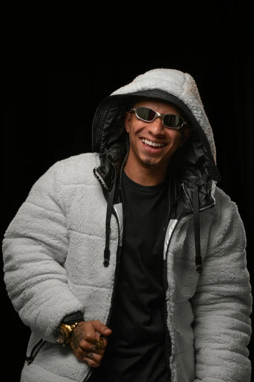 a man smiling with a jacket and sunglasses on
