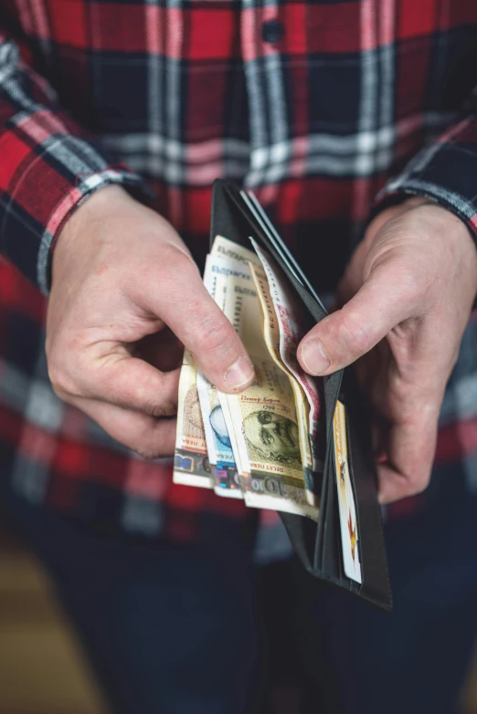 a man opening his wallet with money coming out