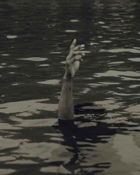 a person's hand in water reaching for soing