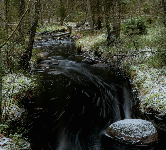 an outdoor creek is shown surrounded by winter snow