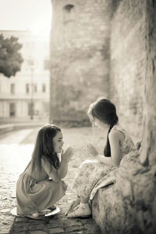 two girls sit outside together talking