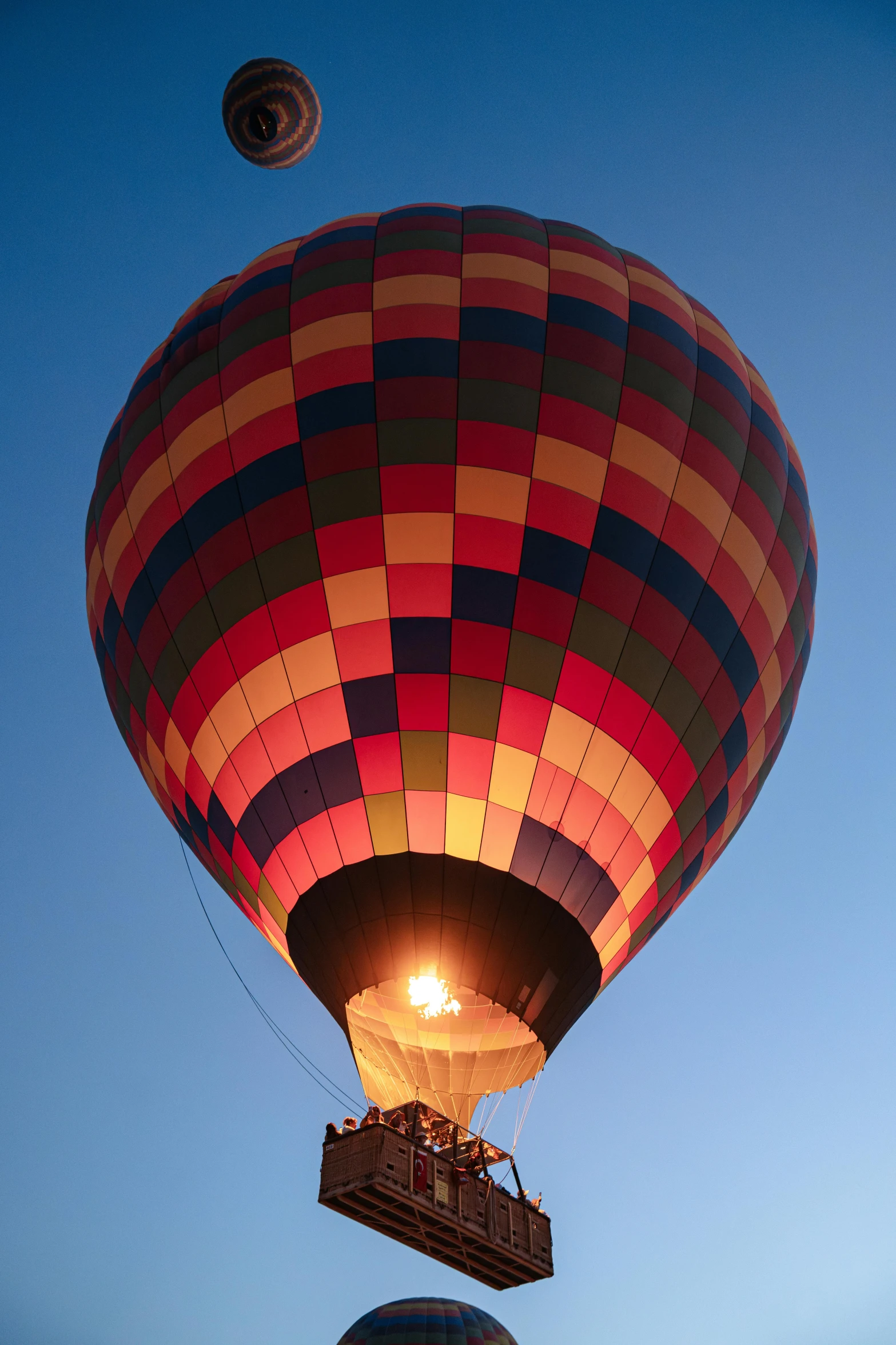 a large  air balloon with the light on and other balloons in the sky