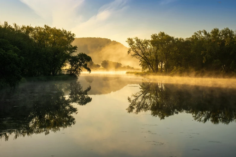 a calm morning on a foggy lake in the sun