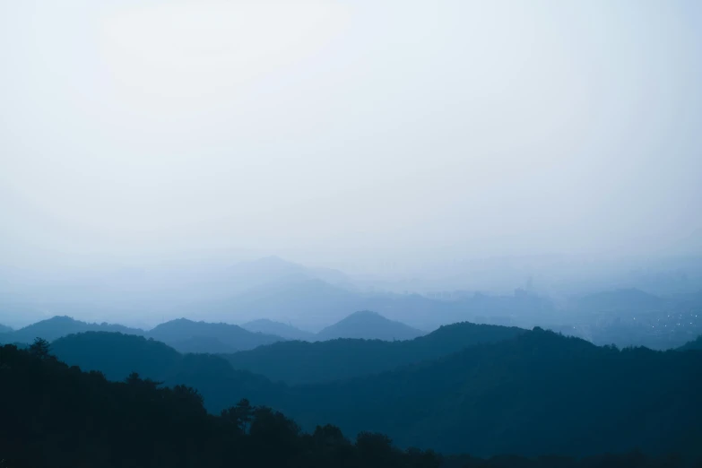 a field with trees in the distance on a foggy day