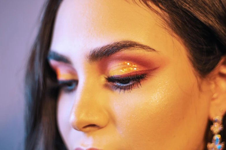 a woman with red and gold eye makeup