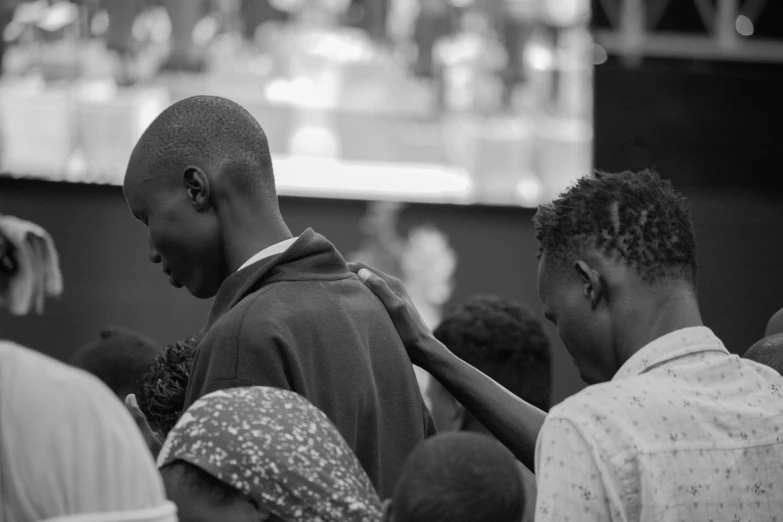 people standing around a black man wearing a tie