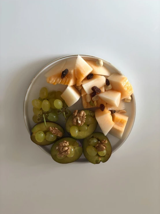 an aerial view of a white plate topped with gs, cheese and nuts