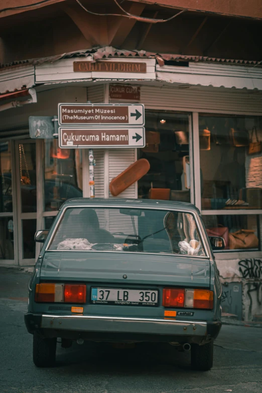 a car with the door open is parked outside a shop