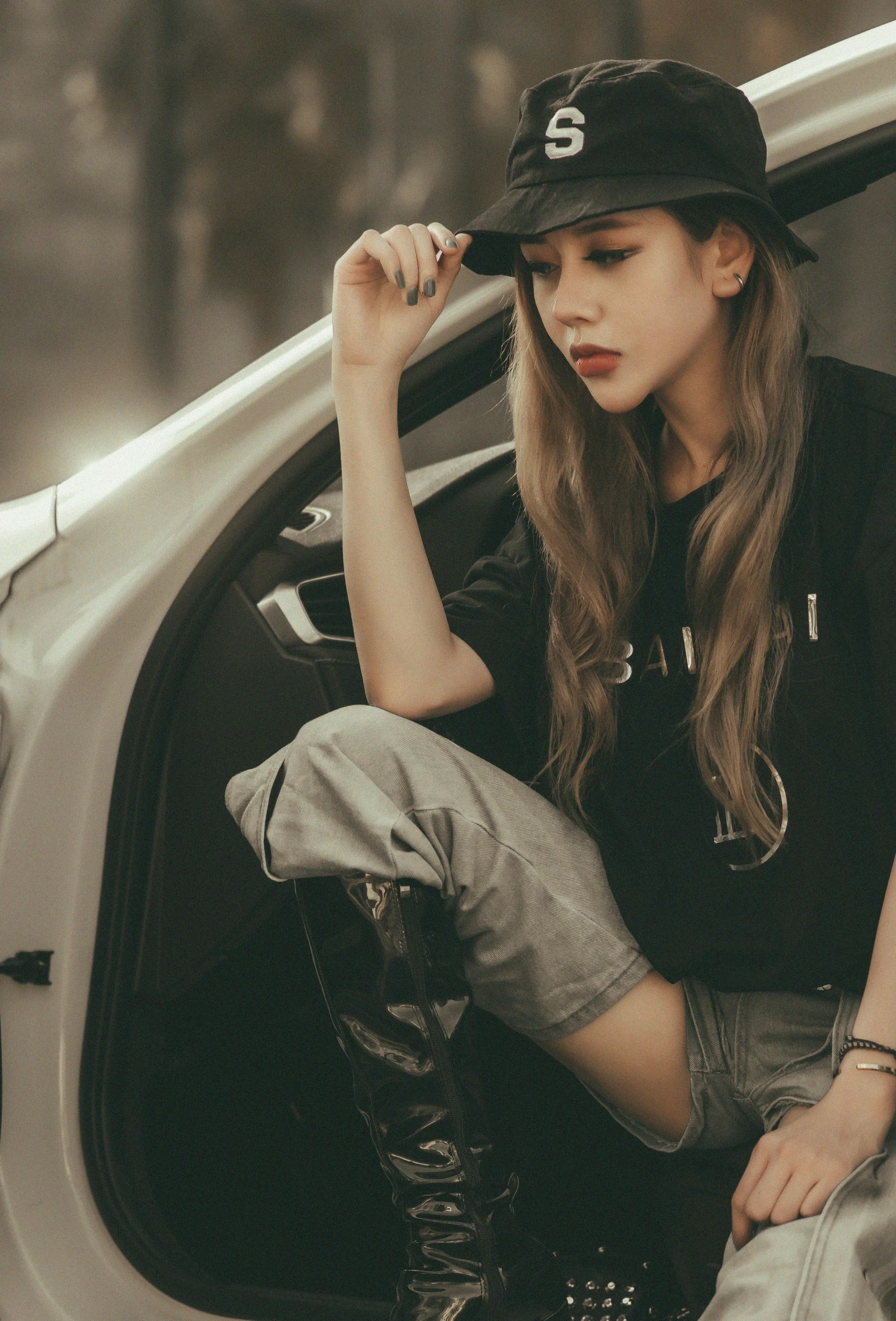 a young woman sitting on the edge of a car