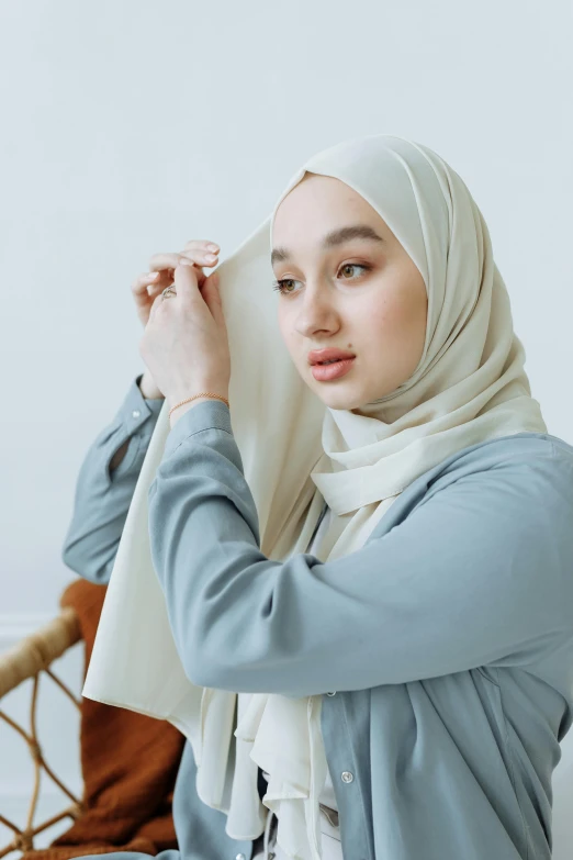 a woman wearing a hijab is sitting down