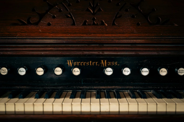 the keys of an upright piano have faces carved into it