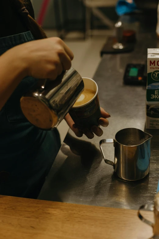 the person is pours coffee into a cup