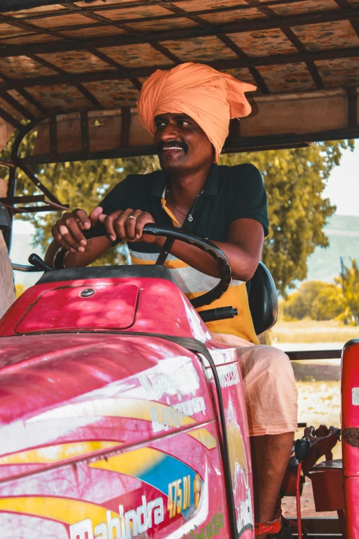 a man driving a tractor and wearing a turban